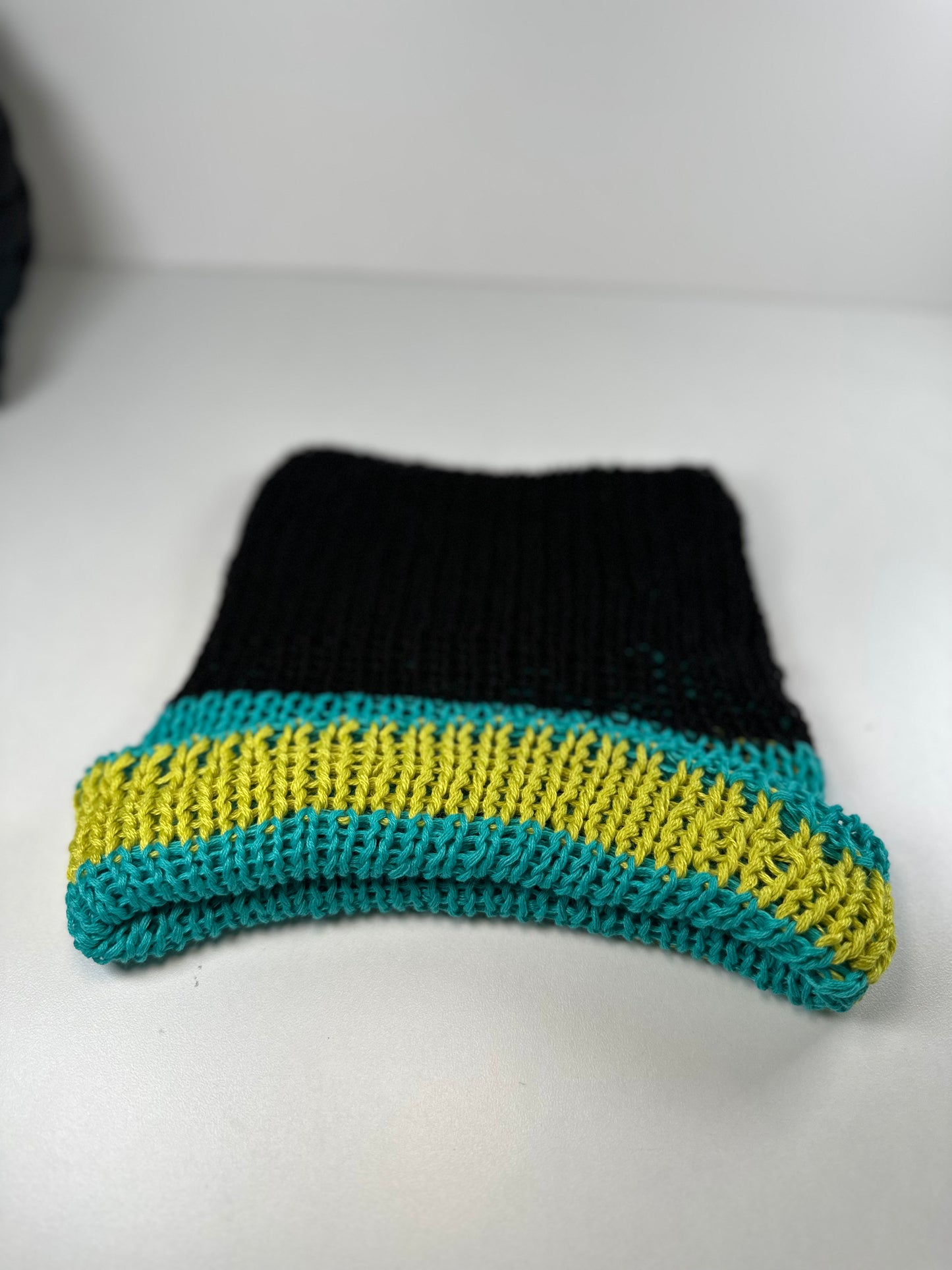 The black, turquoise, and lime green striped beanie
