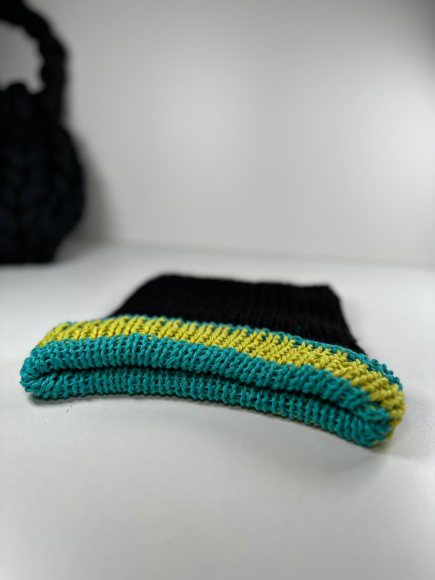 The black, turquoise, and lime green striped beanie